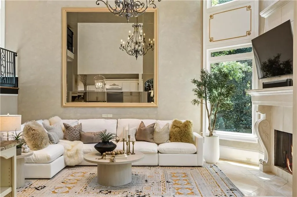 Living room featuring a fireplace, plenty of natural light, and a notable chandelier