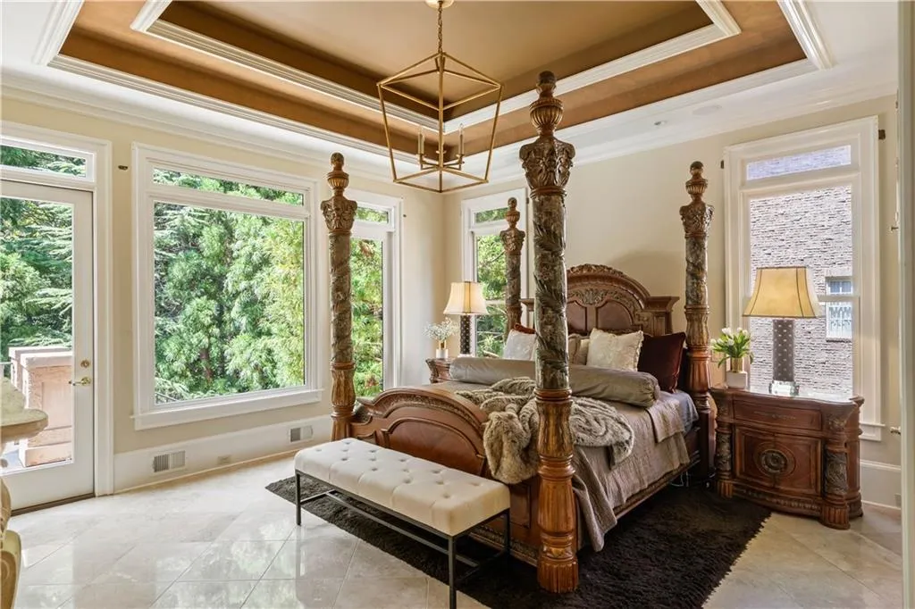 Bedroom featuring access to outside, a raised ceiling, and crown molding