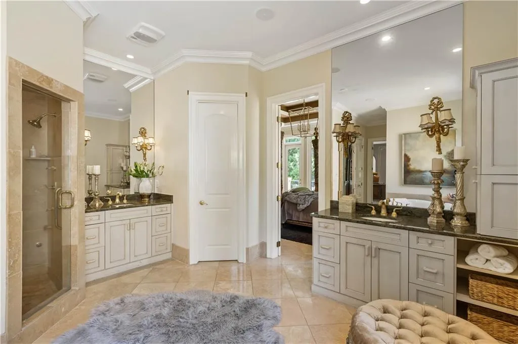 Bathroom with a shower with shower door, tile patterned flooring, ornamental molding, and vanity