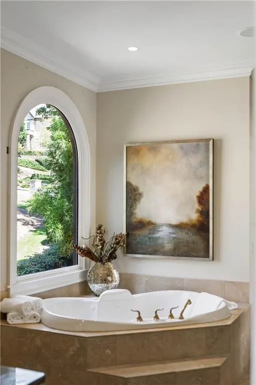 Bathroom with tiled bath and ornamental molding