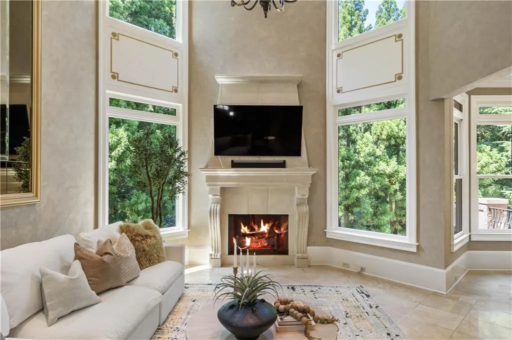Living room with a wealth of natural light, a towering ceiling, and a fireplace