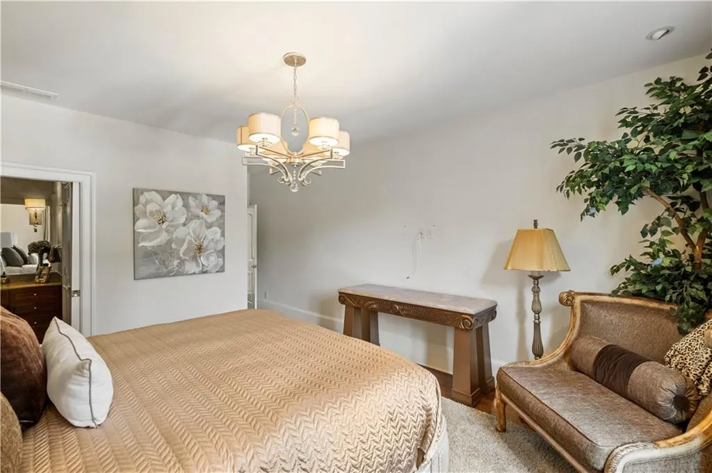 Carpeted bedroom featuring a notable chandelier