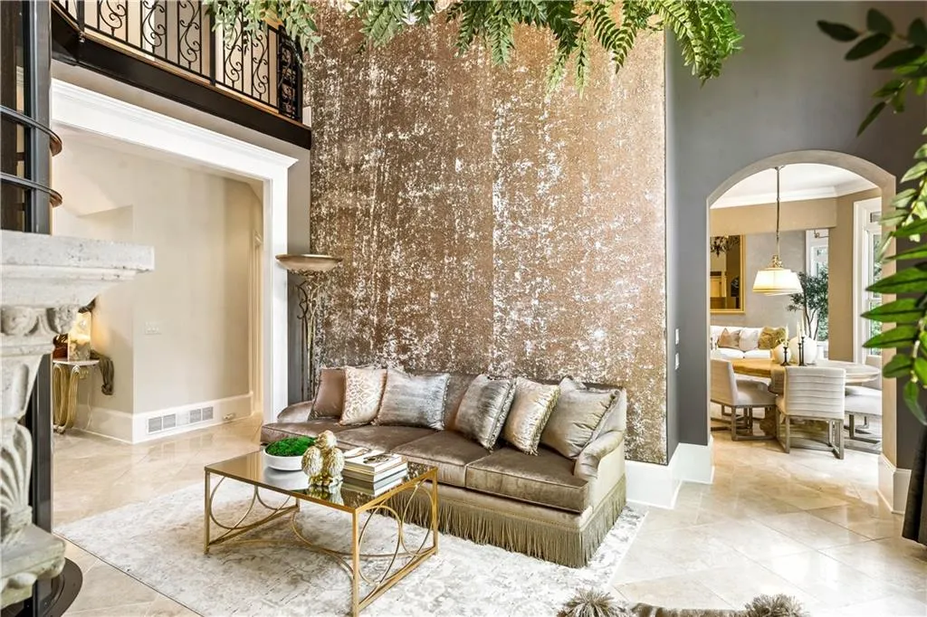Living room featuring crown molding, a towering ceiling, and a high end fireplace