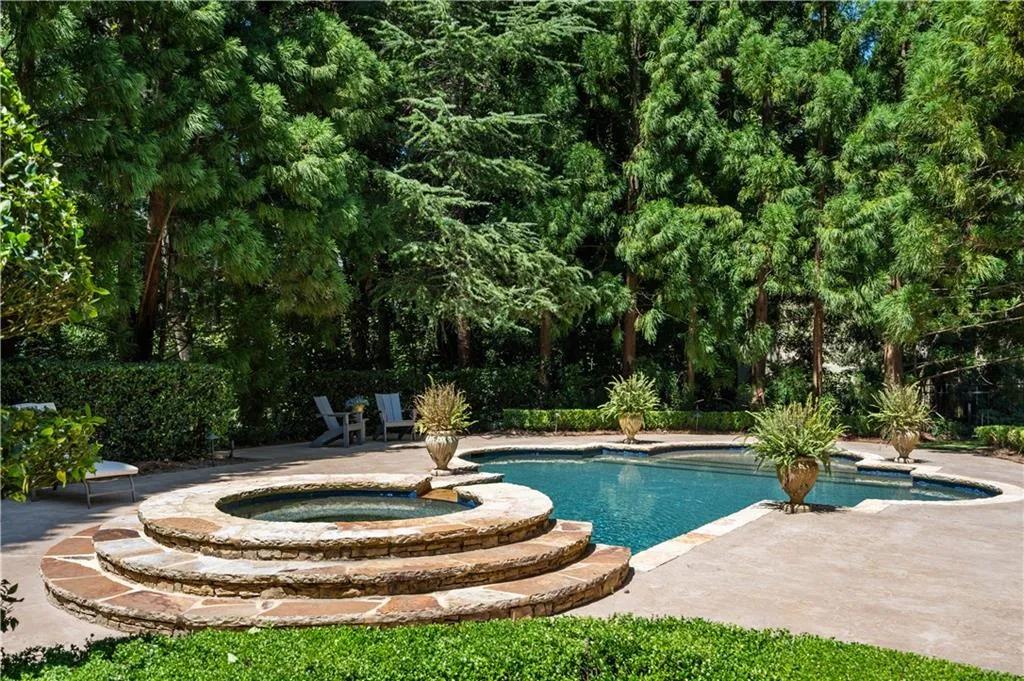 View of pool with an in ground hot tub and a patio