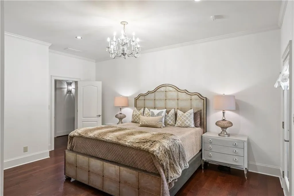 Bedroom featuring dark hardwood / wood-style floors, an inviting chandelier, and crown molding
