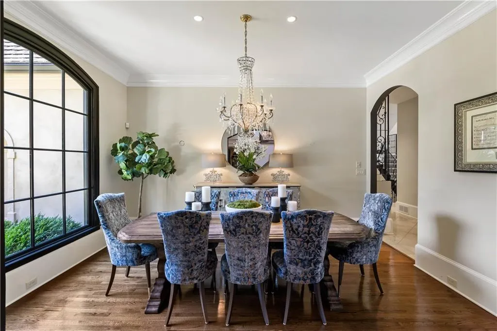 Dining room with ornamental molding, dark wood-type flooring, and an inviting chandelier