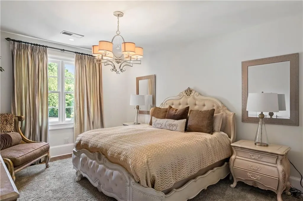 Carpeted bedroom featuring an inviting chandelier