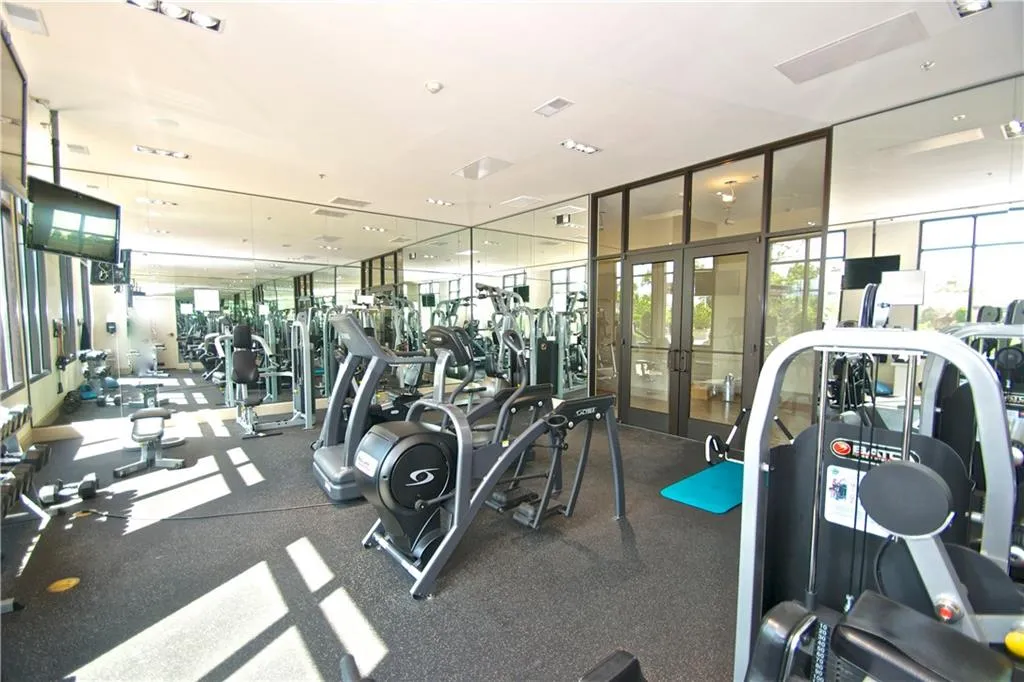 Gym featuring a wall of windows, french doors, and visible vents