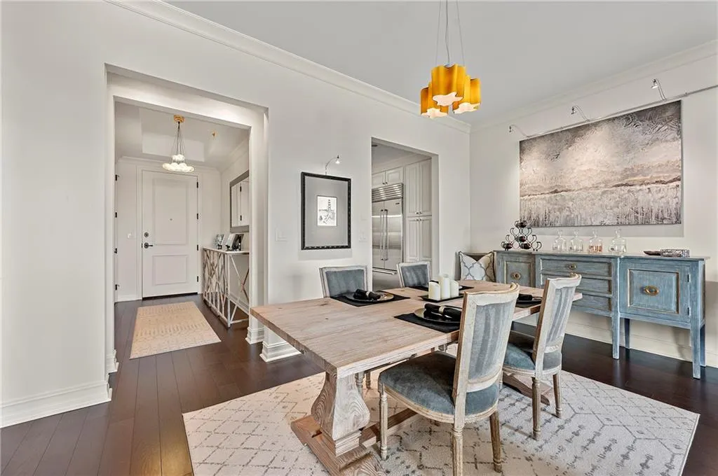 Dining area featuring dark wood floors, baseboards, a chandelier, and ornamental molding