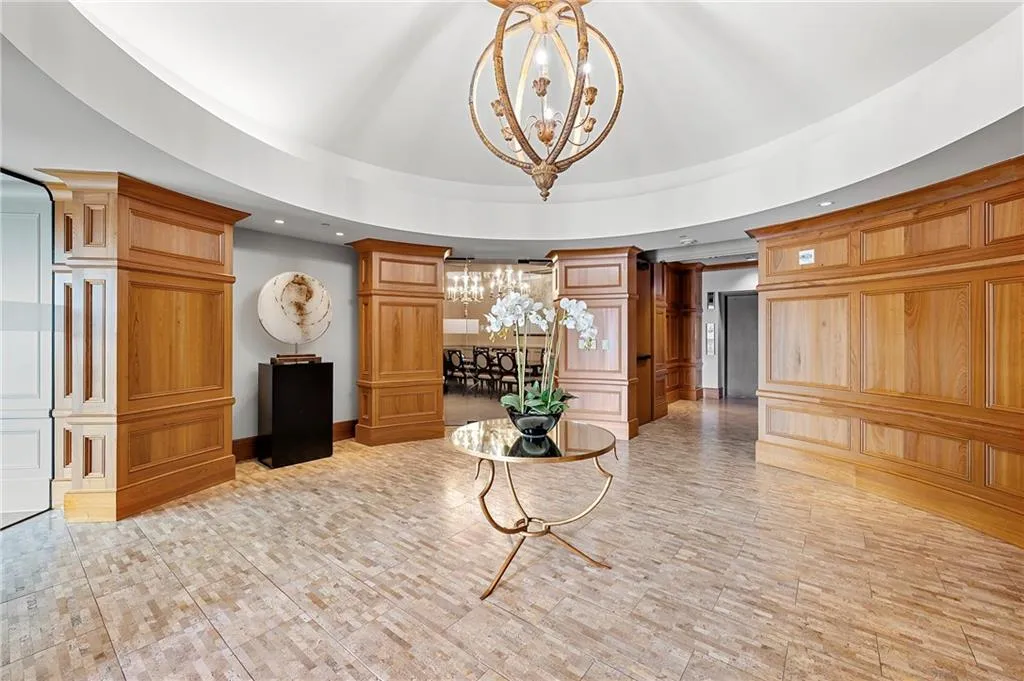 Community area featuring recessed lighting, a tray ceiling, a notable chandelier, and ornate columns