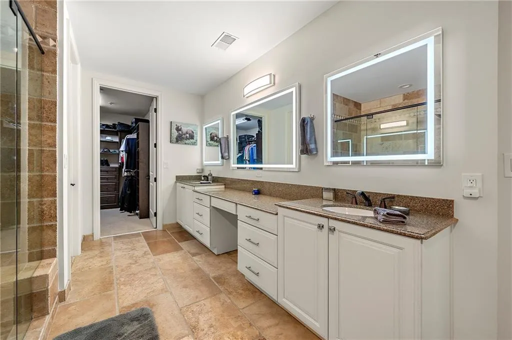 Primary Full bath featuring visible vents, a sink, a shower stall, double vanity, and a spacious closet