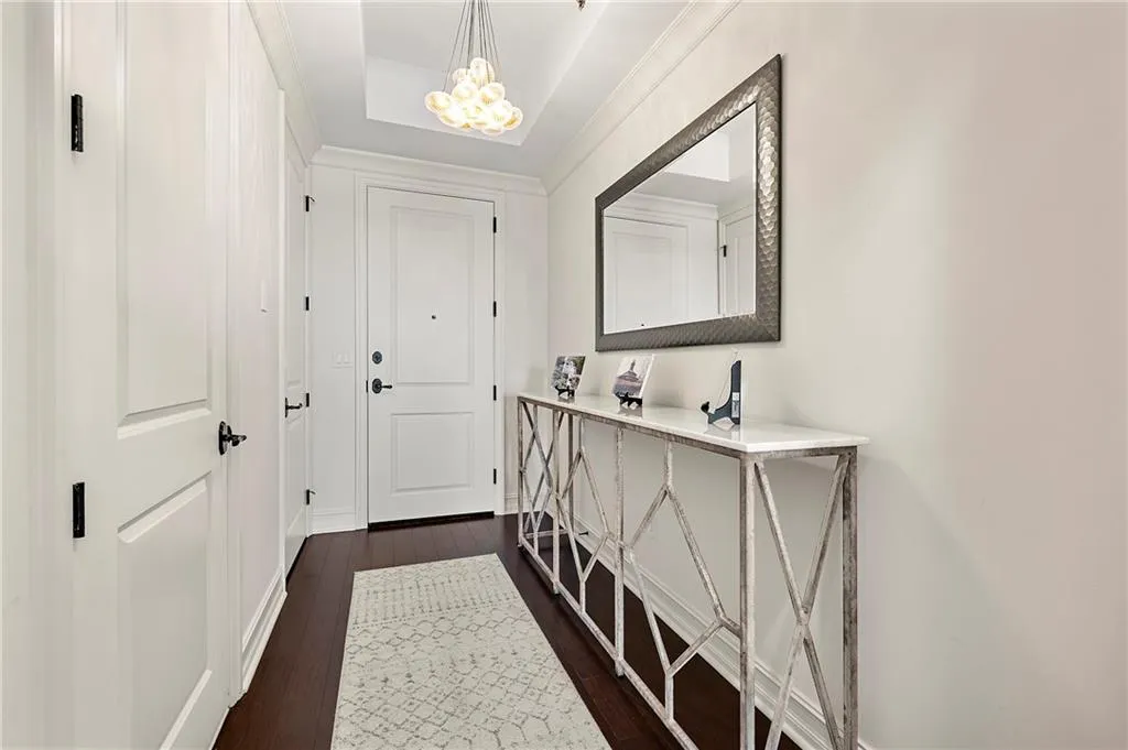 Doorway to outside featuring a notable chandelier and dark wood flooring