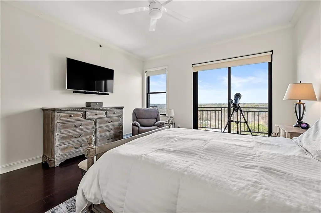 Primary Bedroom with baseboards, dark wood floors, crown molding, and access to outside