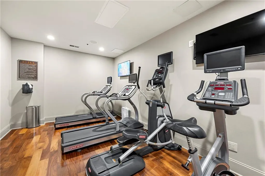Gym featuring cardiovascular room, recessed lighting, baseboards, and wood finished floors
