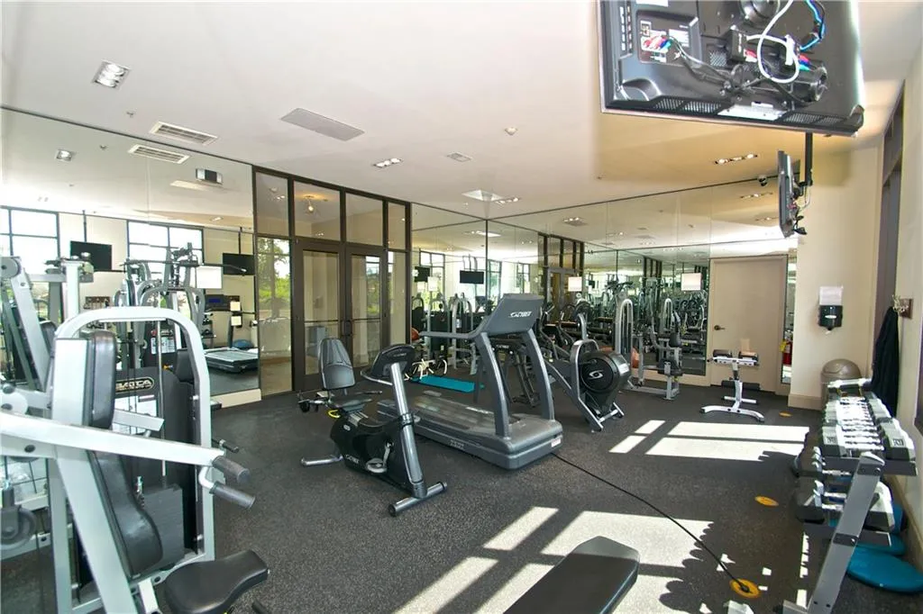 Exercise room featuring visible TV's and expansive windows