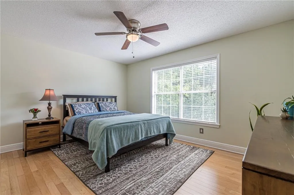 Master Bedroom featuring light hardwood floors, fresh paint, and new ceiling fan.