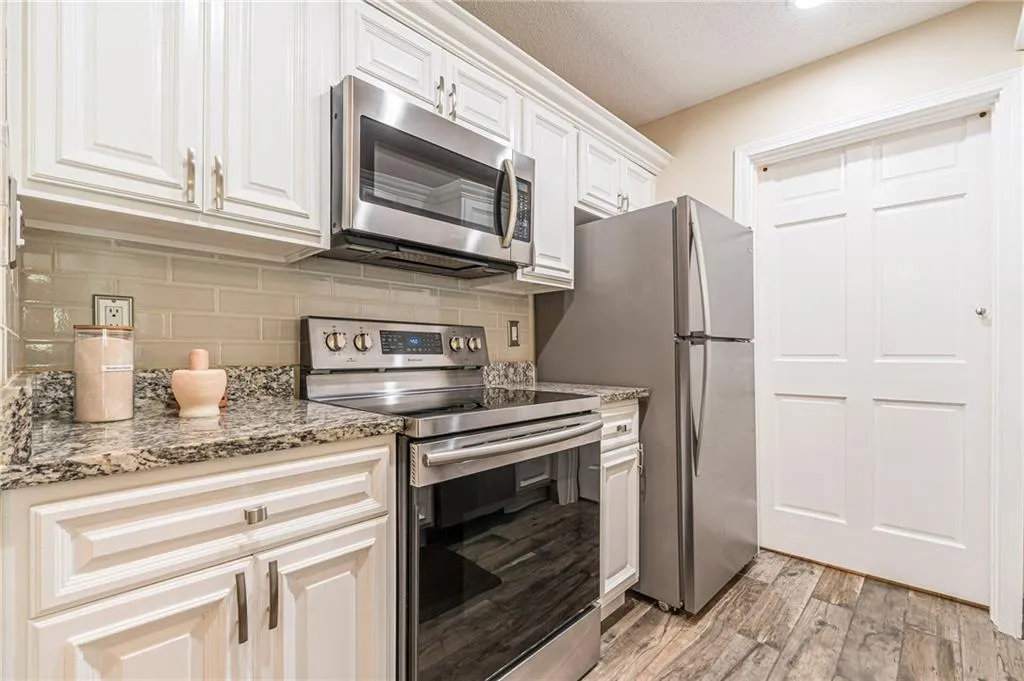 White Cabinets, updated backsplash, tile flooring, and appliances.