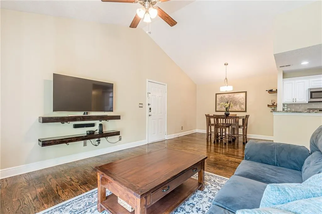 Living room featuring high vaulted ceiling, tv built-in unit, and engineered hardwood flooring throughout.