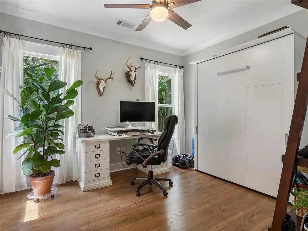 Office space featuring ceiling fan, crown molding, and light wood-type flooring