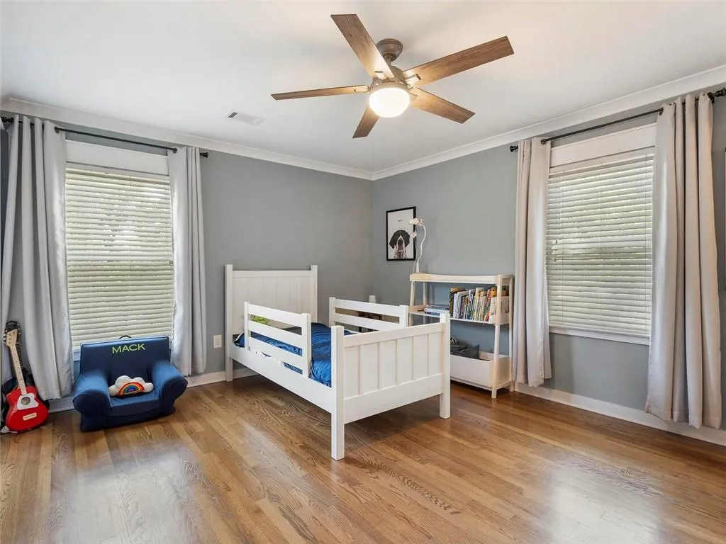 Bedroom with crown molding, ceiling fan, and hardwood / wood-style floors