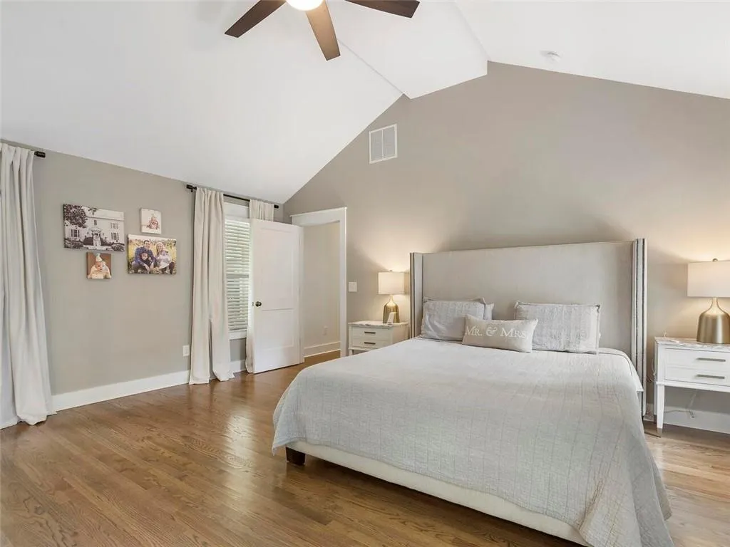 Bedroom featuring high vaulted ceiling, hardwood / wood-style flooring, and ceiling fan