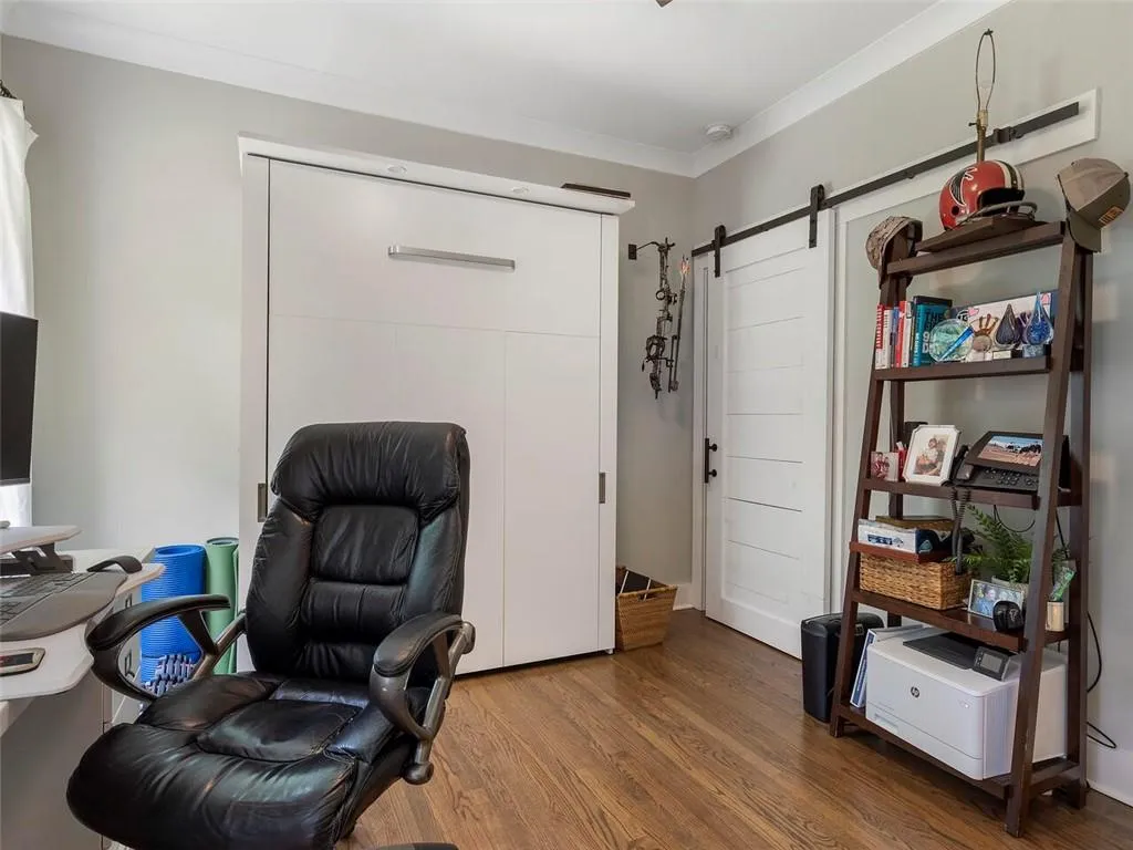 Office space with hardwood / wood-style floors, a barn door, and crown molding