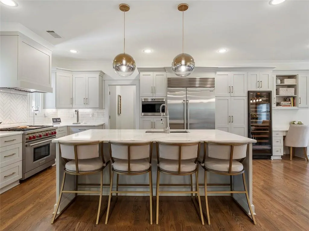Kitchen featuring high quality appliances, dark hardwood / wood-style flooring, decorative light fixtures, backsplash, and sink