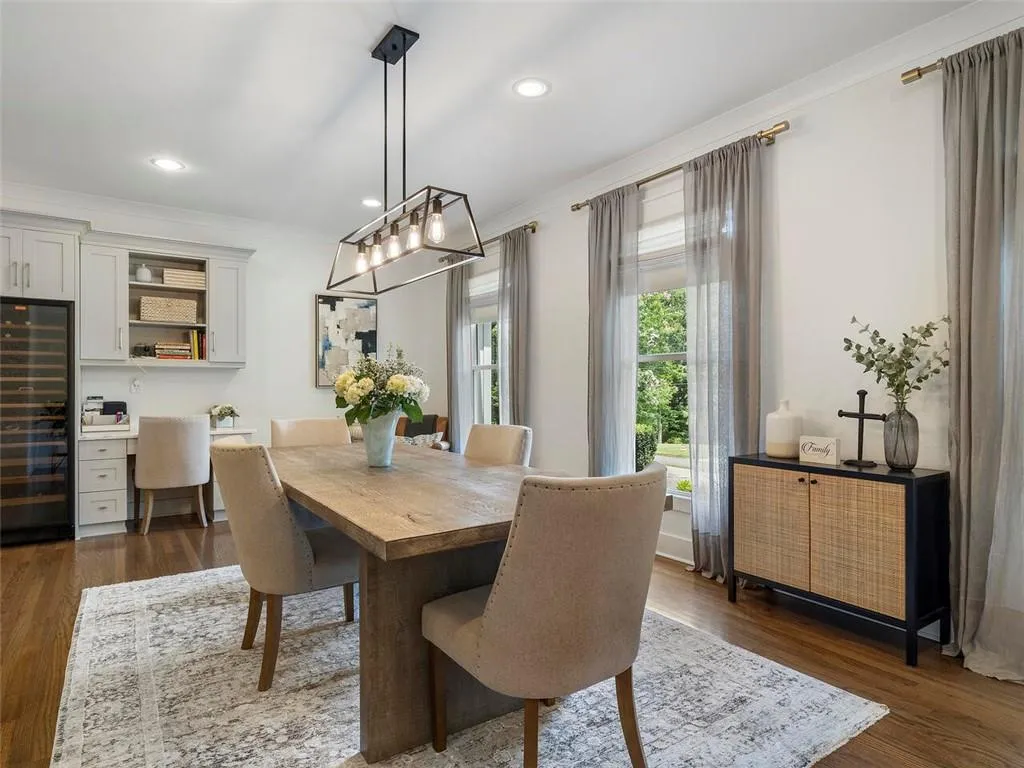 Dining space with an inviting chandelier, ornamental molding, and dark hardwood / wood-style floors