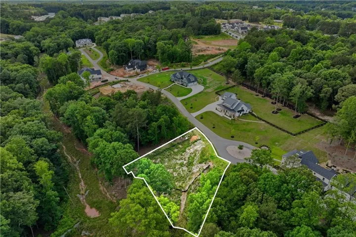Aerial view showing the entire property and surrounding trees