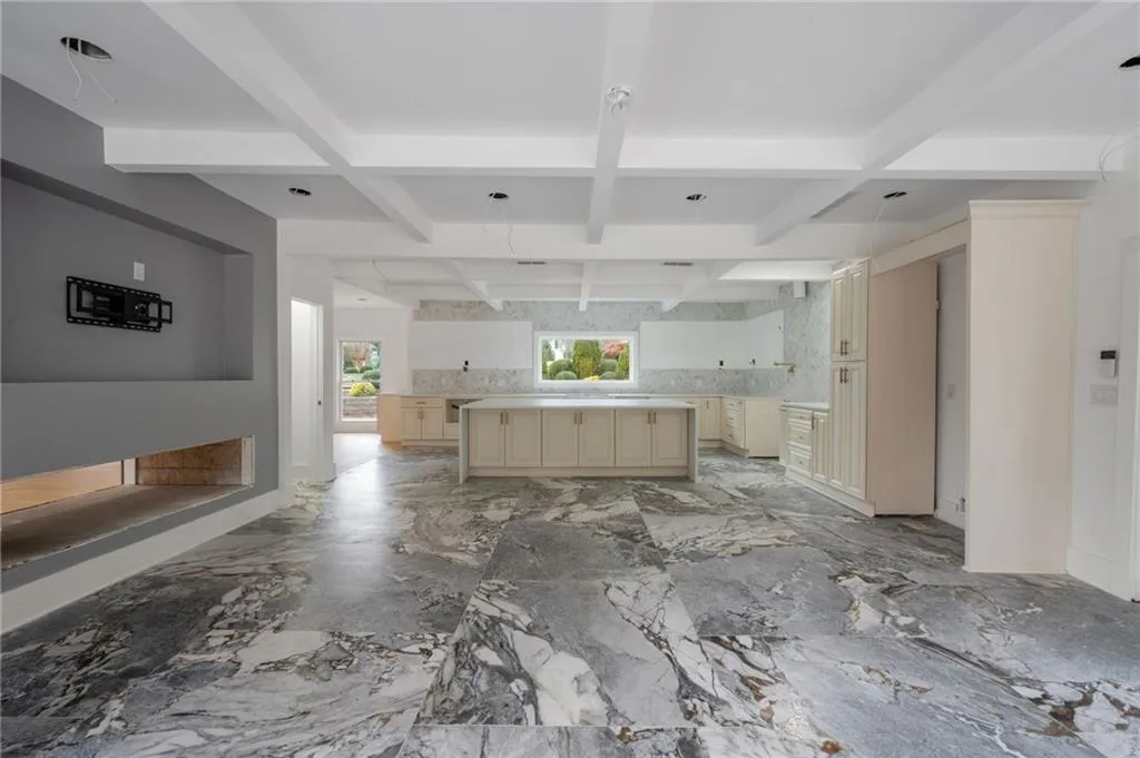 Kitchen with beamed ceiling, cream cabinetry, and coffered ceiling
