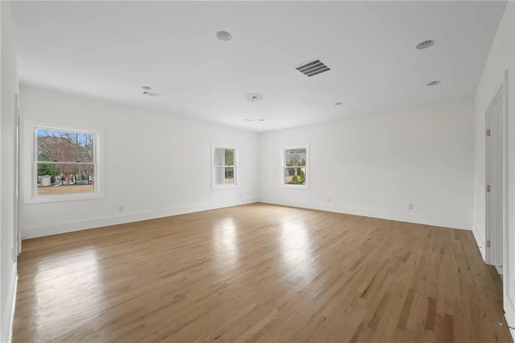 Empty room with light wood-type flooring and plenty of natural light