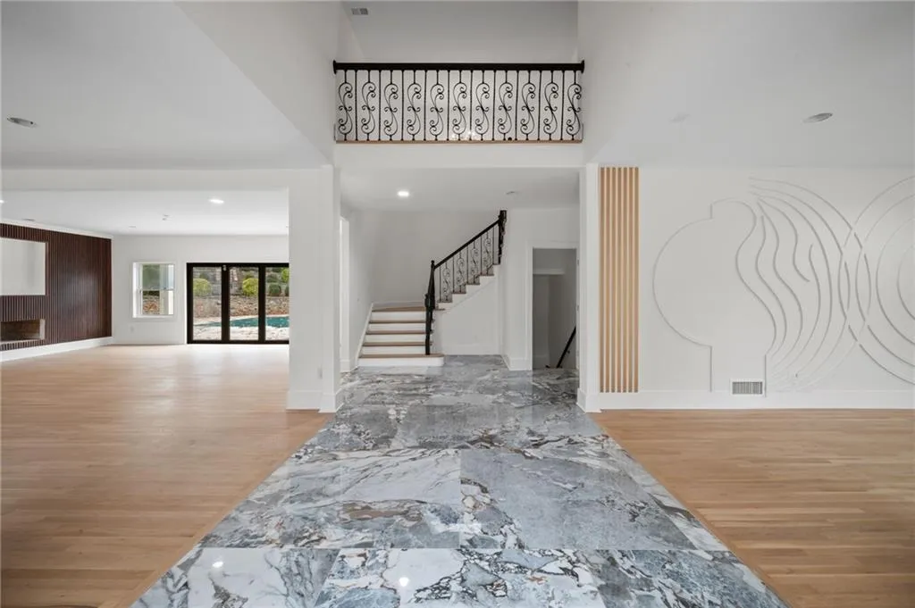 Entrance foyer featuring wood-type flooring and a towering ceiling
