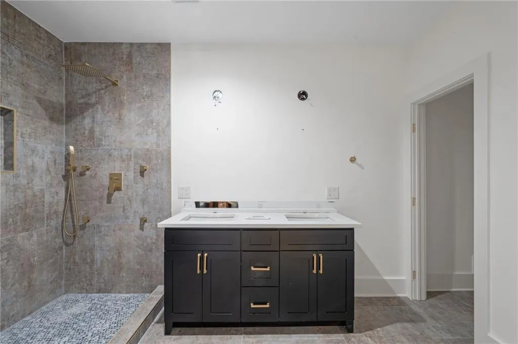 Bathroom with tiled shower and vanity
