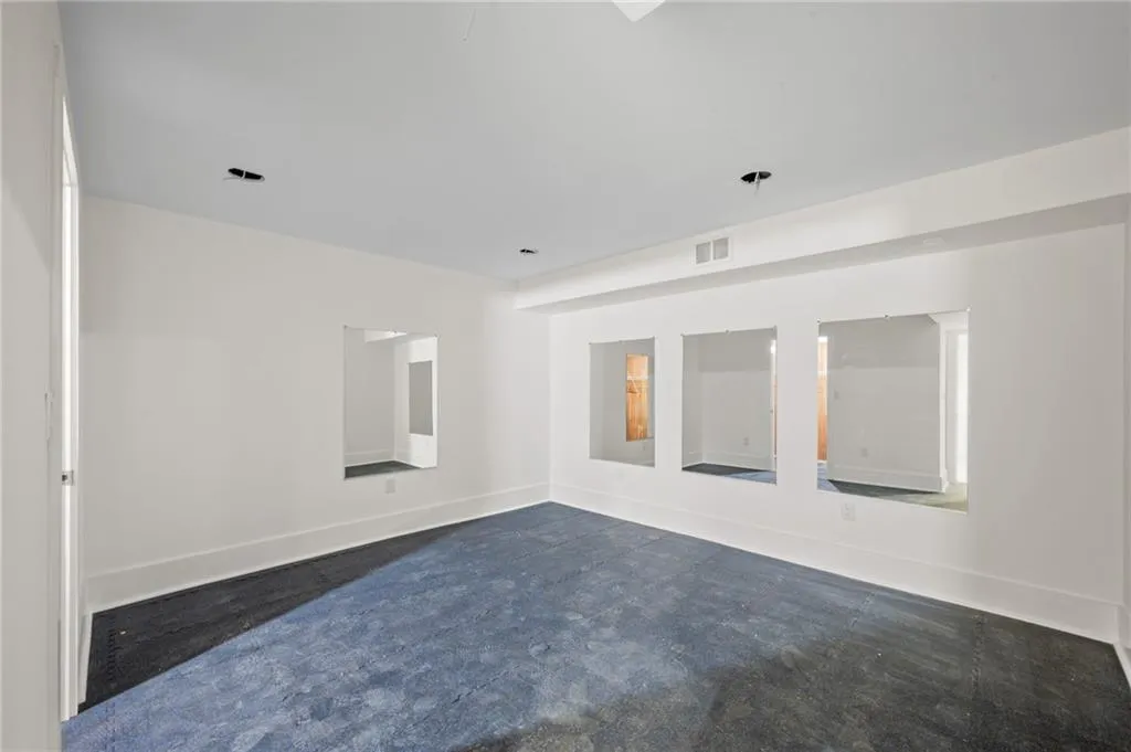 Spare room with dark colored carpet