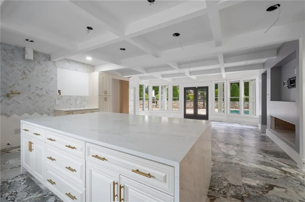 Kitchen featuring white cabinets, french doors, a kitchen island, and coffered ceiling