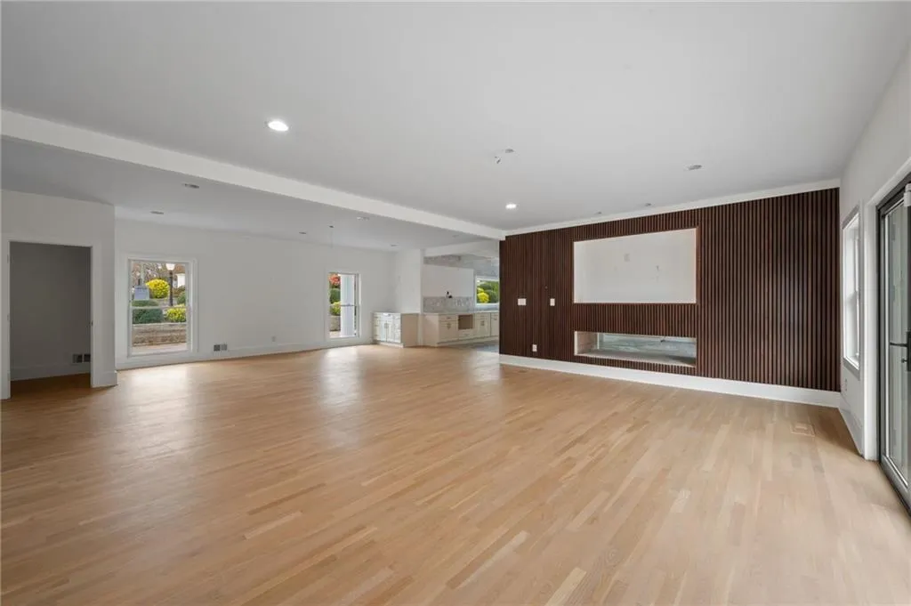 Unfurnished living room with wood walls and light hardwood / wood-style flooring