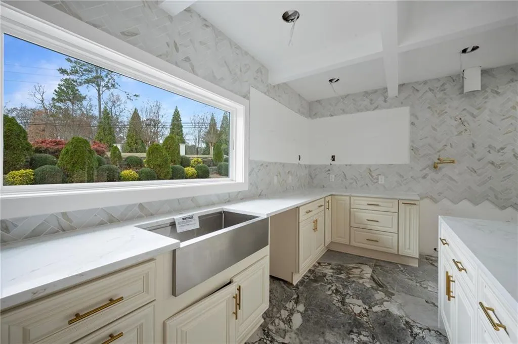 Kitchen with light stone countertops and cream cabinetry