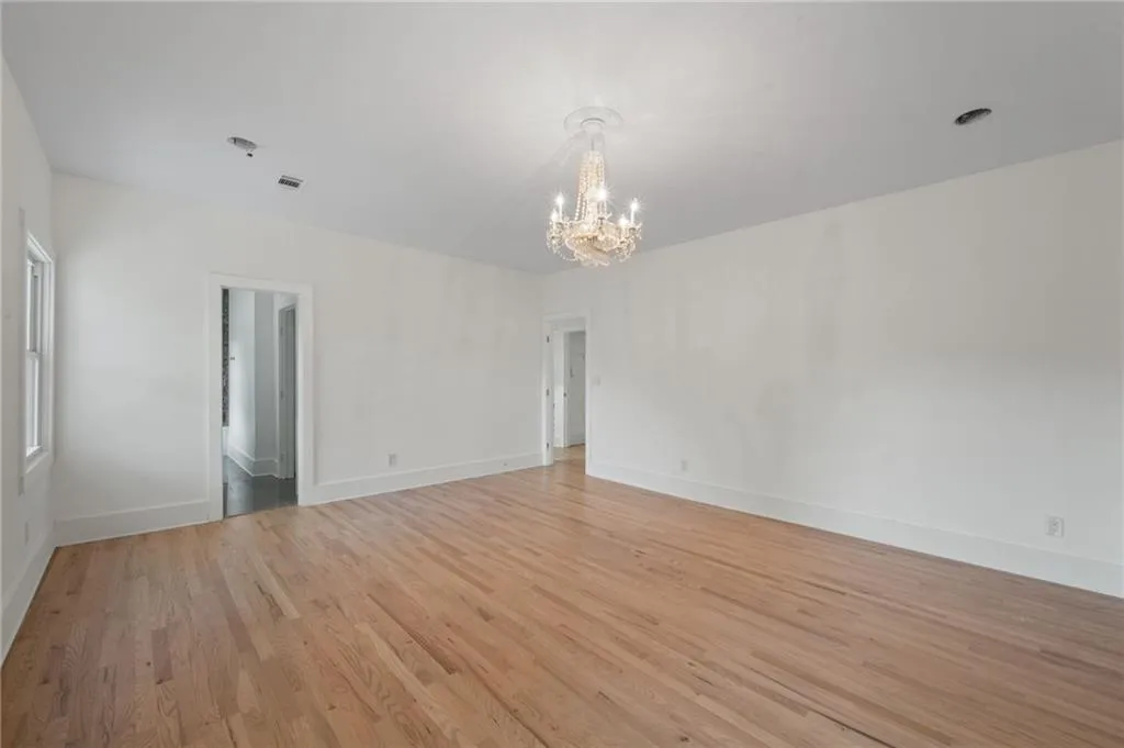 Spare room featuring a chandelier and light hardwood / wood-style floors