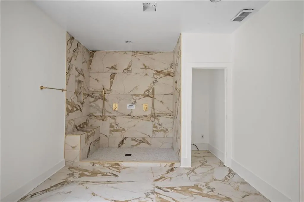 Bathroom featuring a shower and tile walls