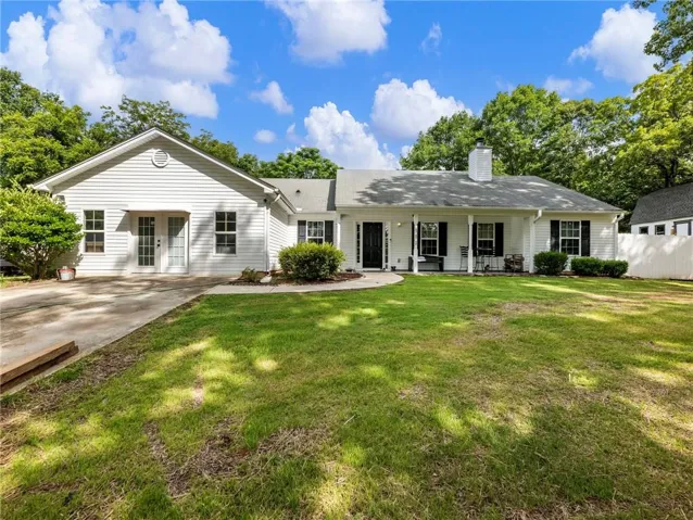 White siding exterior with a covered front porch featuring white columns and a central chimney
