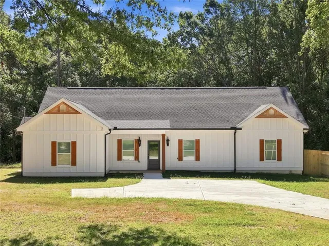 White board-and-batten exterior with prominent gables featuring natural wood accents
