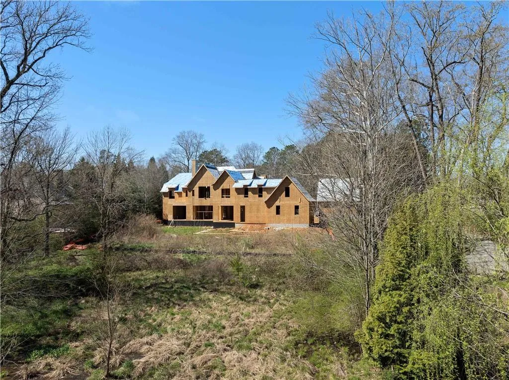 Back of property with stucco siding, a chimney, and solar panels