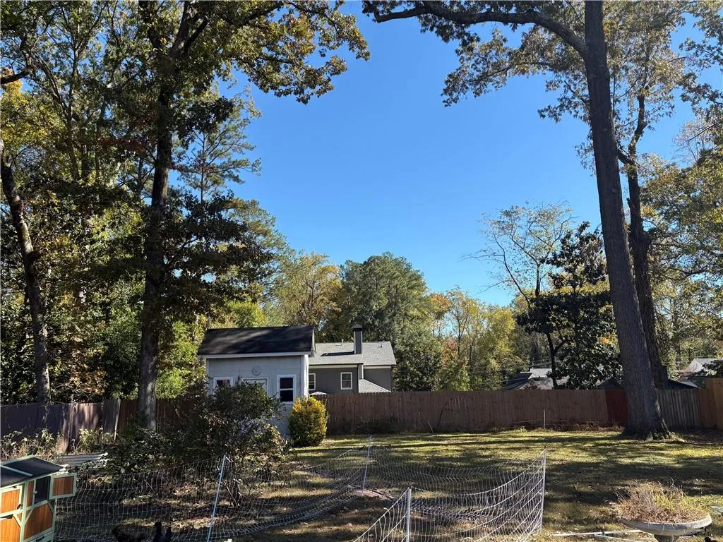 Fenced backyard featuring view of wooded area