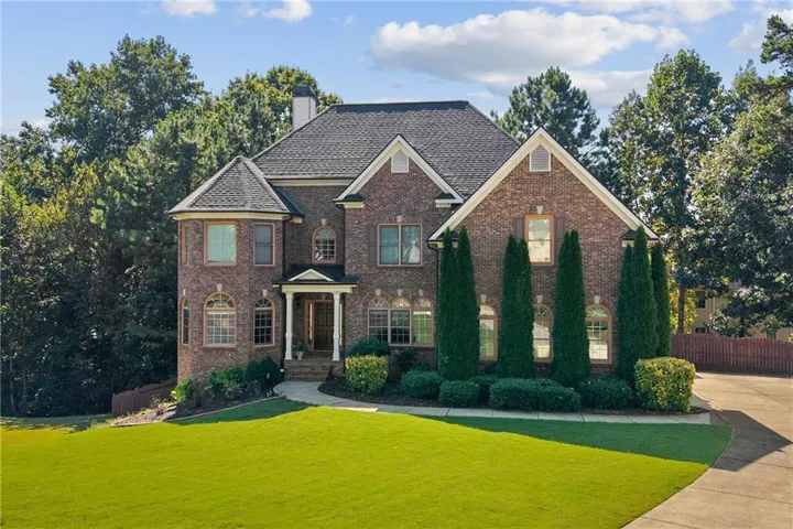 Brick exterior with a prominent turret, columned entry, and arched windows