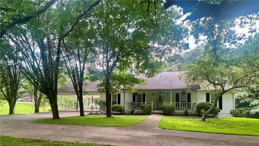 Ranch-style residence featuring white siding and black shutters