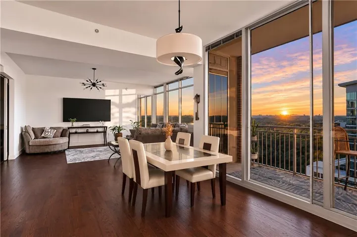Expansive living area featuring rich wood-finish flooring, a contemporary drum pendant light, and a modern sputnik chandelier