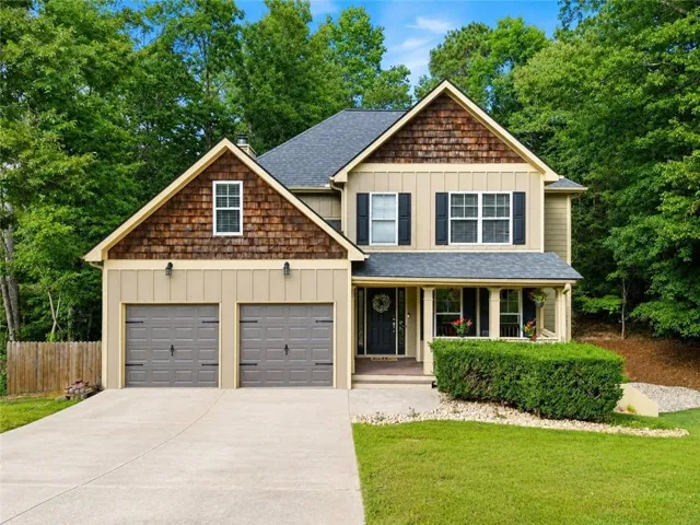 Two-story residence featuring board and batten siding, shake siding accents, and a covered front porch