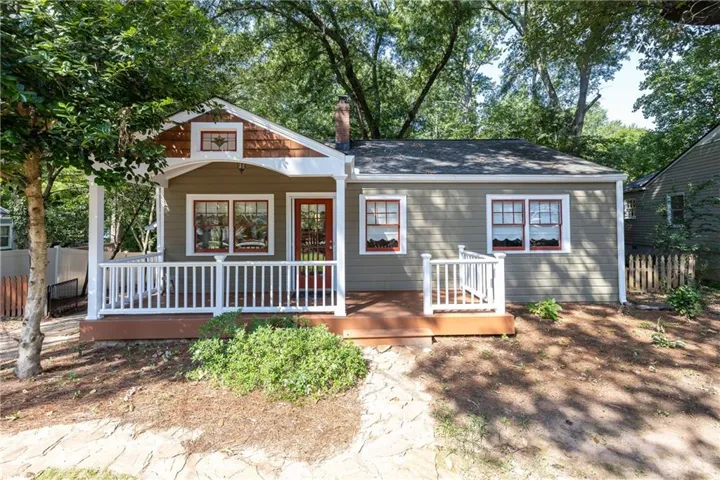 Covered front porch with white railing and wood flooring