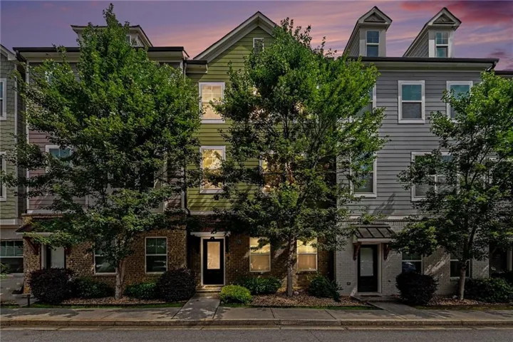 Multi-story townhouse facade featuring a combination of brick and horizontal siding