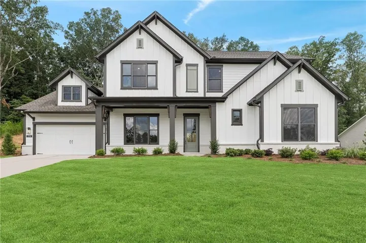 Modern farmhouse exterior with white board-and-batten siding and dark trim accents